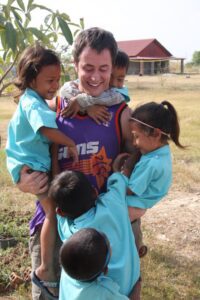 Dr. Johnson plays with some kids in Cambodia during a humanitarian dental trip.